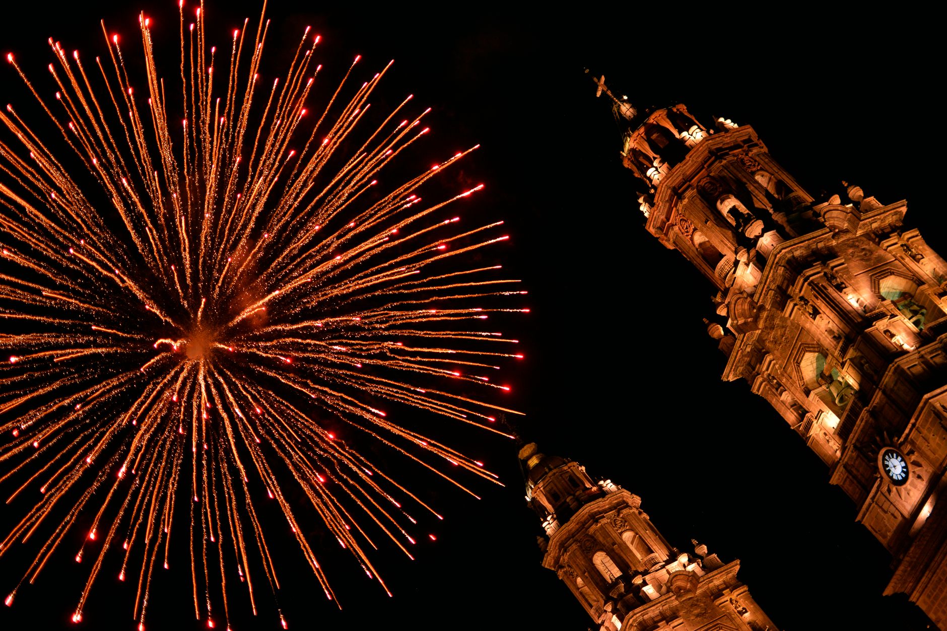 Fireworks illuminate Morelia Cathedral's baroque architecture on a festive night.